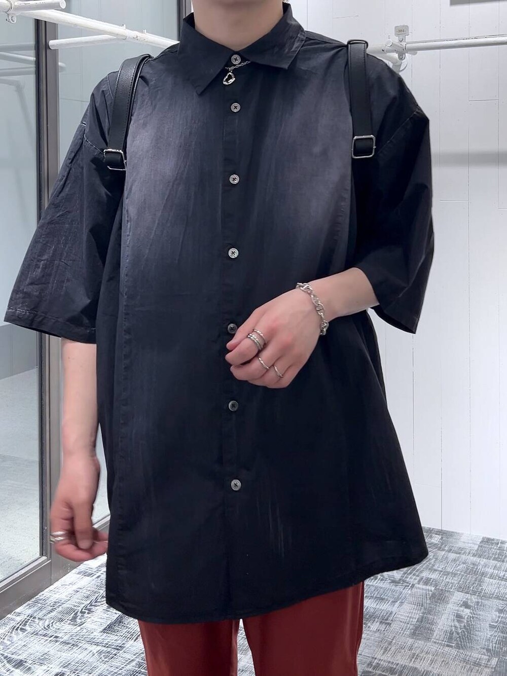 ブラック系のサンダル、ブラック系のショルダーバッグ、オレンジ系のスラックスを着用したメンズの春コーディネートの5枚目の写真