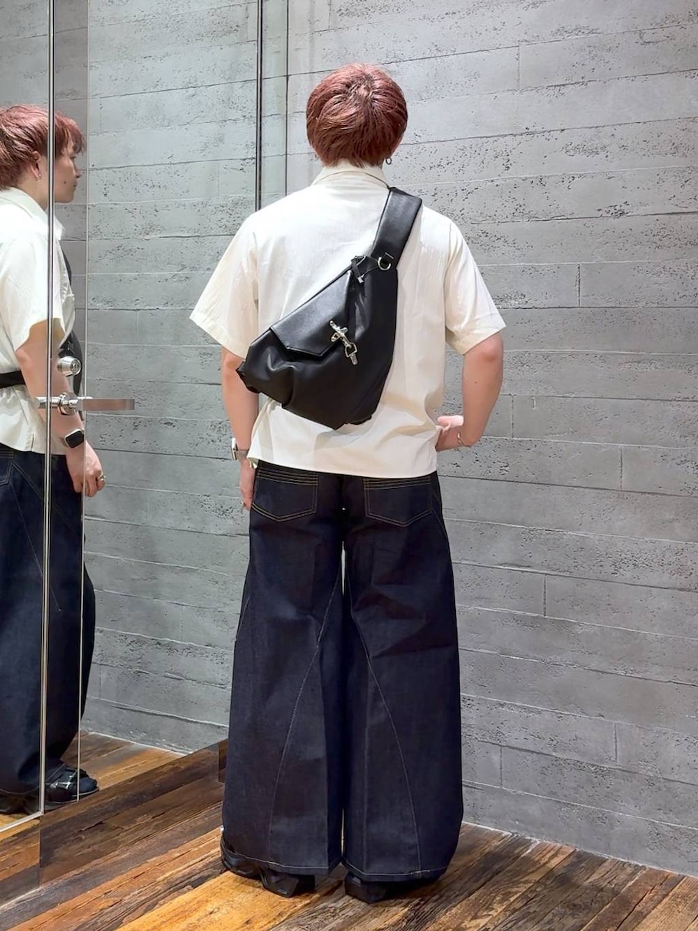 ブラック系のサンダル、ブルー系のデニムパンツ、ブラック系のショルダーバッグを着用したメンズの夏コーディネートの3枚目の写真