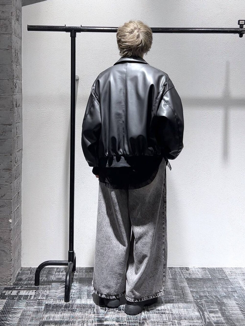 ブラック系のスニーカー、ブラック系のブルゾン、ブラック系のショルダーバッグを着用したメンズの冬コーディネートの4枚目の写真