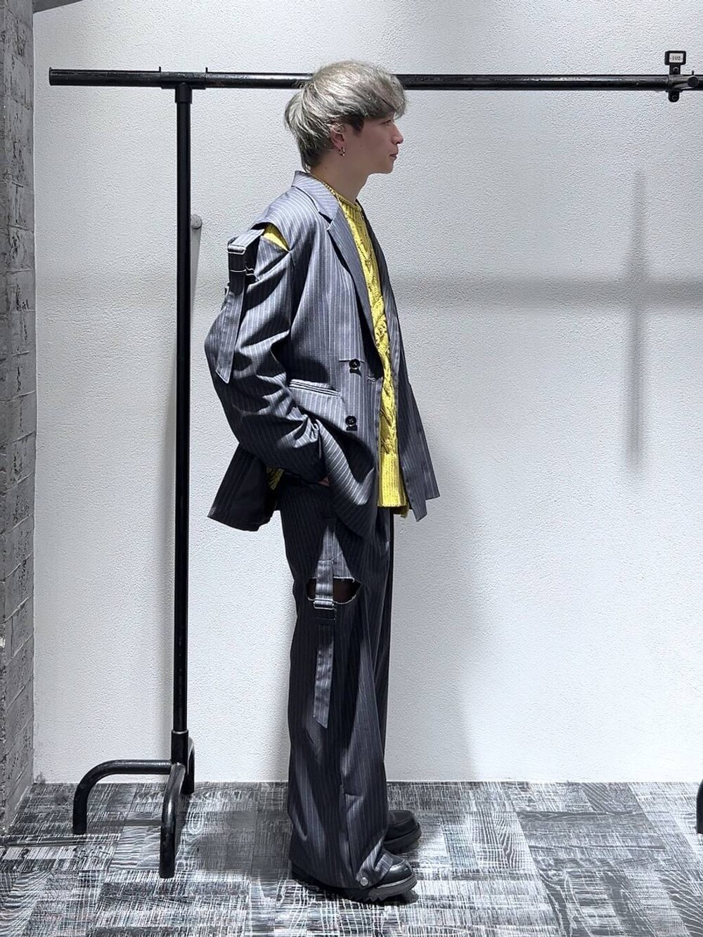 グレー系のテーラードジャケット、グレー系のスラックス、ブラック系のドレスシューズを着用したメンズの冬コーディネートの2枚目の写真