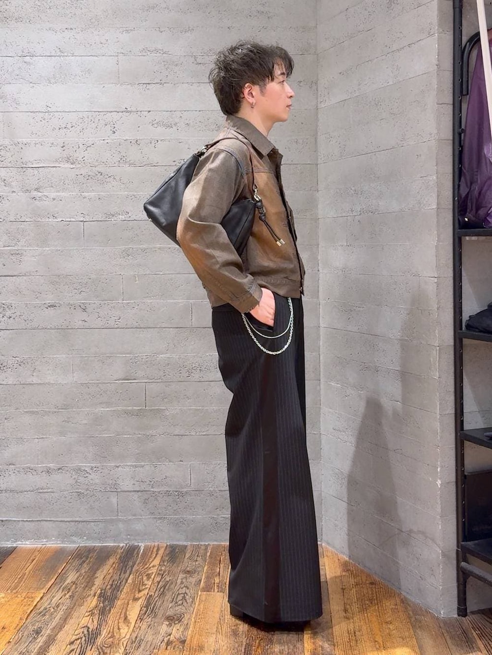 ブラウン系のデニムジャケット、ブラック系のスラックス、ブラック系のTシャツ/カットソーを着用したメンズの夏コーディネートの2枚目の写真
