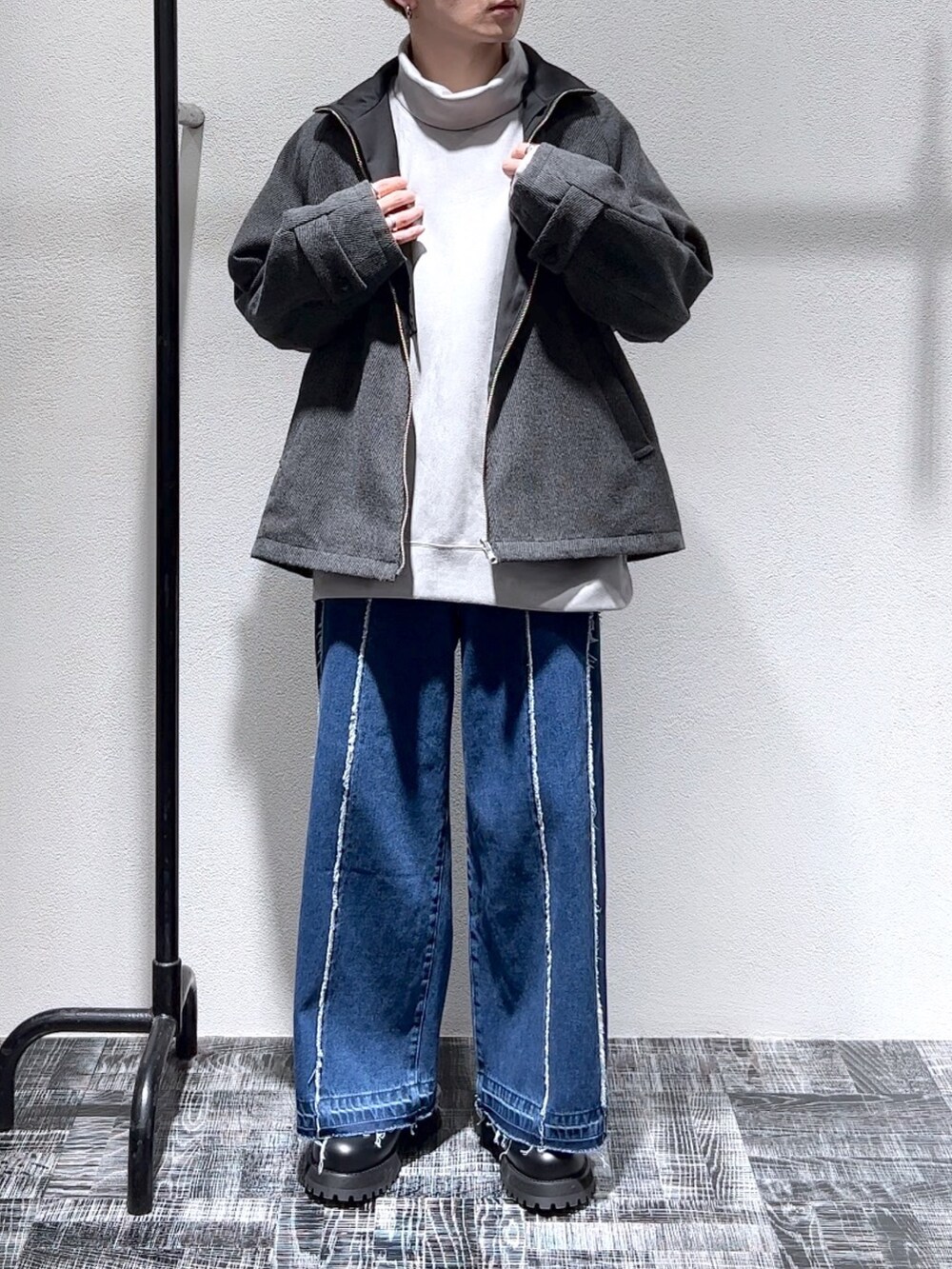 グレー系のスウェット、ブルー系のデニムパンツ、ブラック系のジャケット/アウターを着用したメンズの秋コーディネートの2枚目の写真