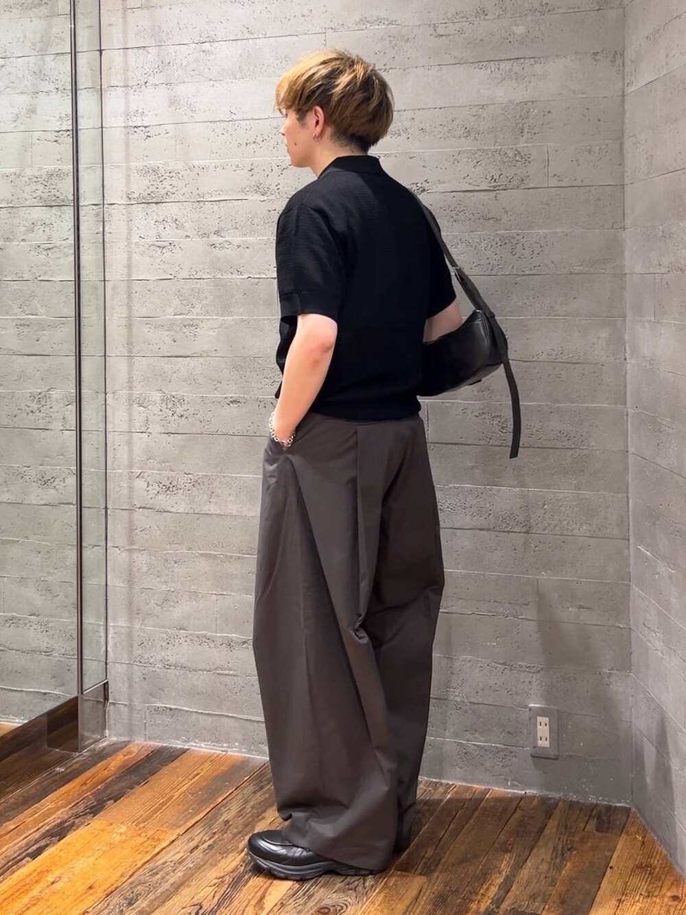 ブラック系のショルダーバッグ、ブラック系のローファー、グレー系のチノパンツを着用したメンズの夏コーディネートの2枚目の写真