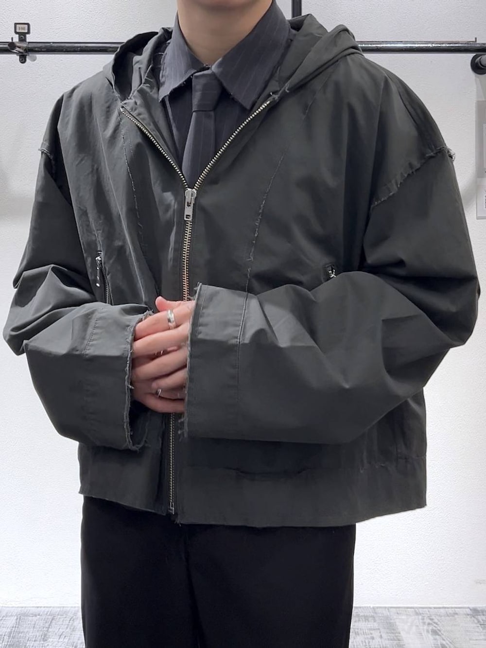 ブラック系のスニーカー、ブラック系のスラックス、グレー系のパーカーを着用したメンズの冬コーディネートの5枚目の写真