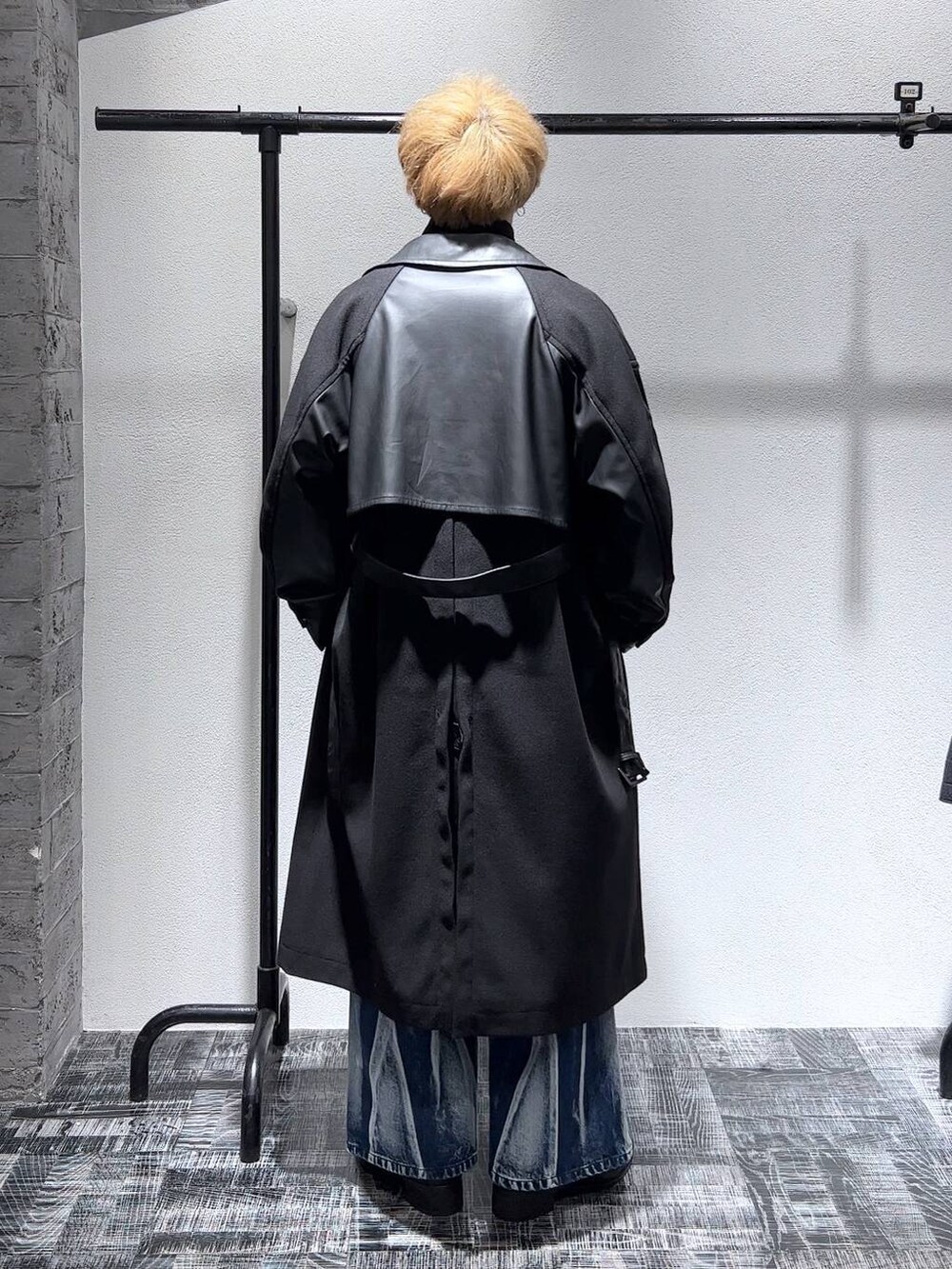 ブラック系のトレンチコート、ブラック系のショルダーバッグ、ブラック系のスウェットを着用したメンズの秋コーディネートの4枚目の写真