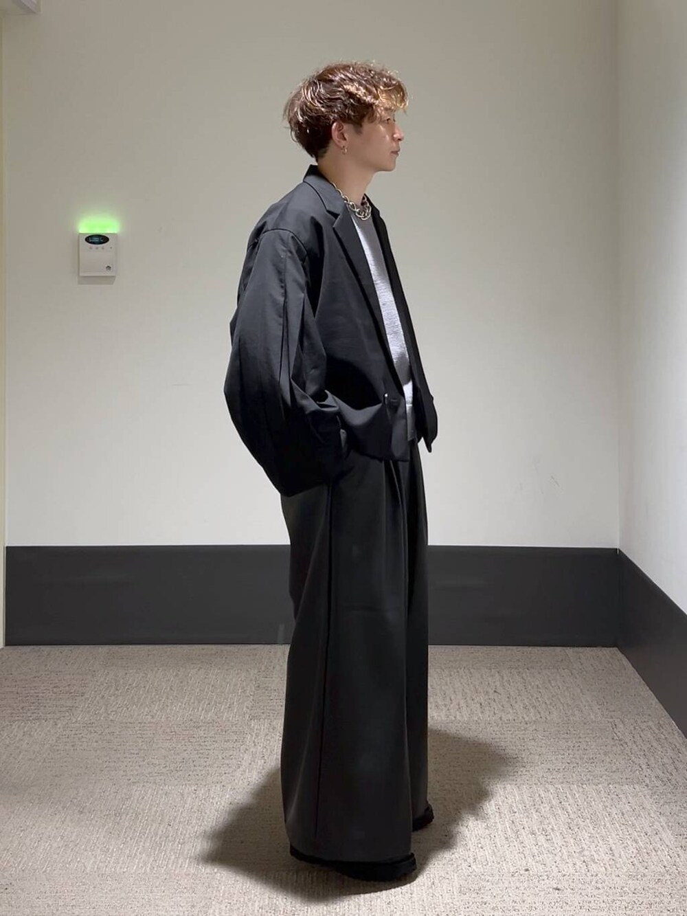 ブラック系のその他パンツ、ブラック系のテーラードジャケット、グレー系のニット/セーターを着用したメンズの秋コーディネートの4枚目の写真