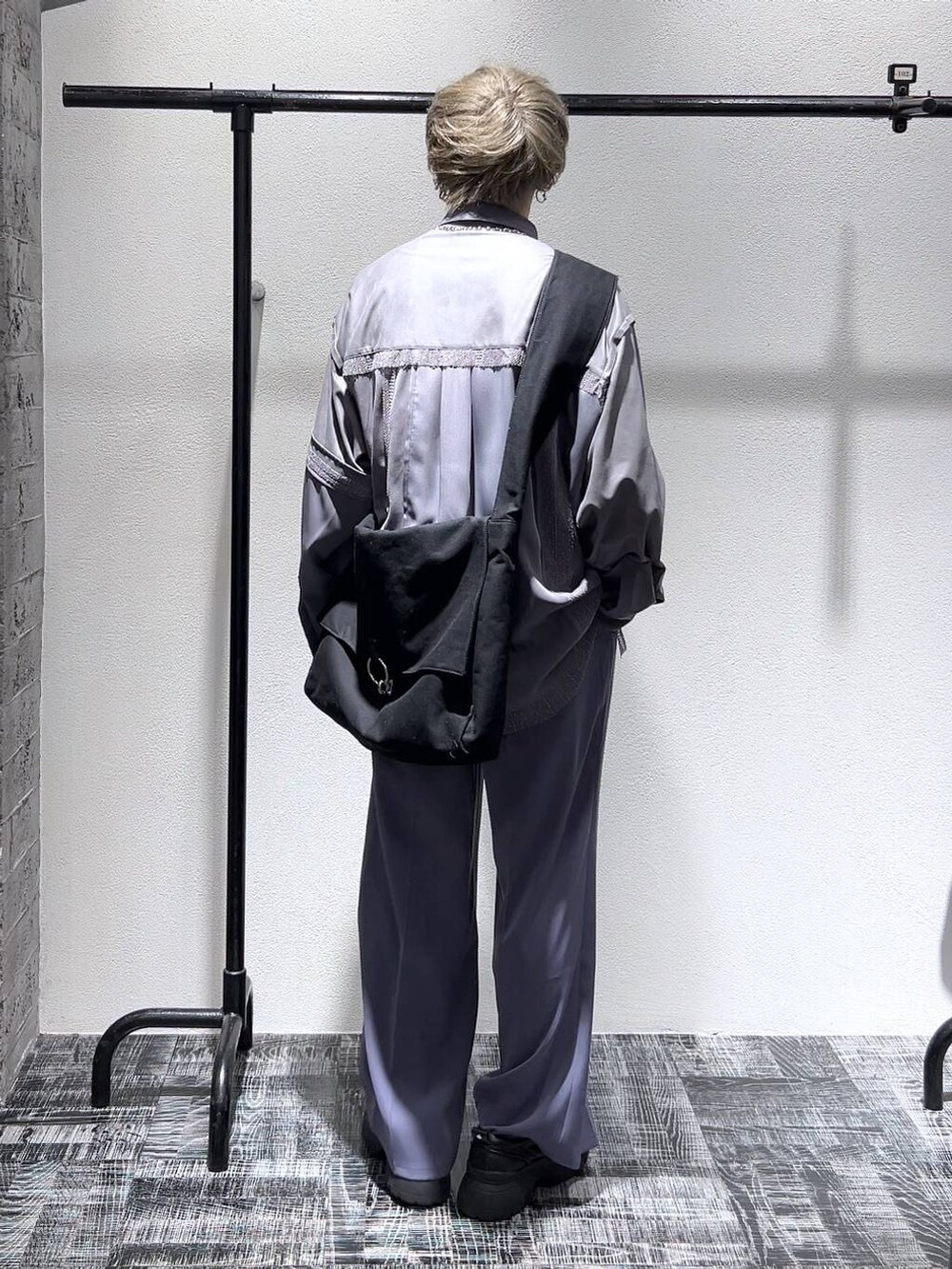 ブラック系のスニーカー、パープル系のスラックス、ブラック系のショルダーバッグを着用したメンズの春コーディネートの4枚目の写真