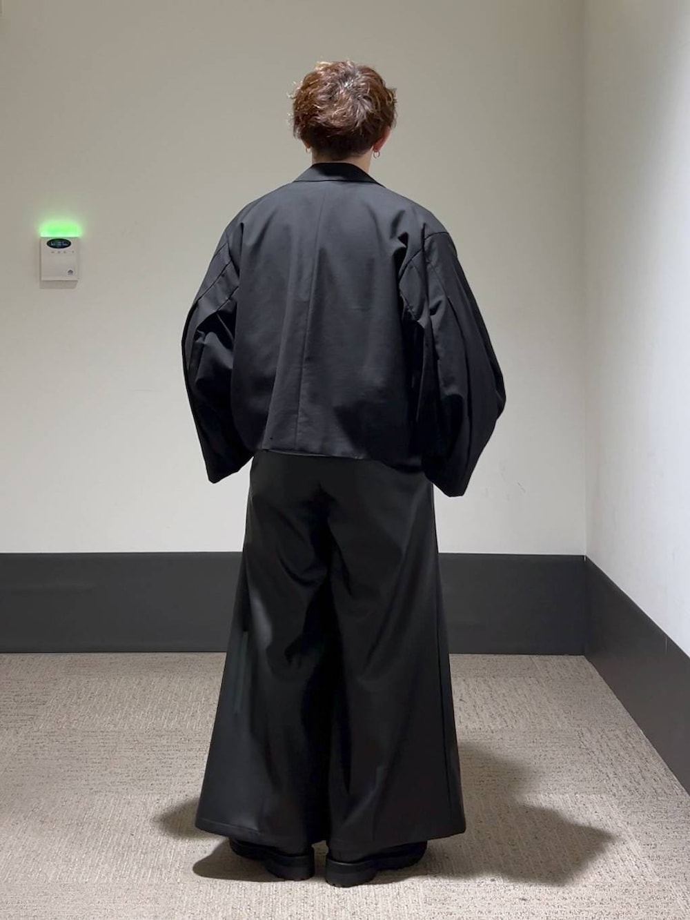 ブラック系のその他パンツ、ブラック系のテーラードジャケット、グレー系のニット/セーターを着用したメンズの秋コーディネートの3枚目の写真