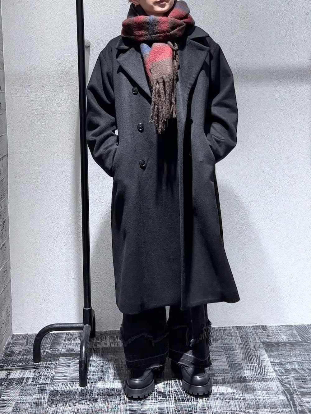 ブラック系のステンカラーコート、ブラック系のローファー、ブラック系のデニムパンツを着用したメンズの秋コーディネートの2枚目の写真