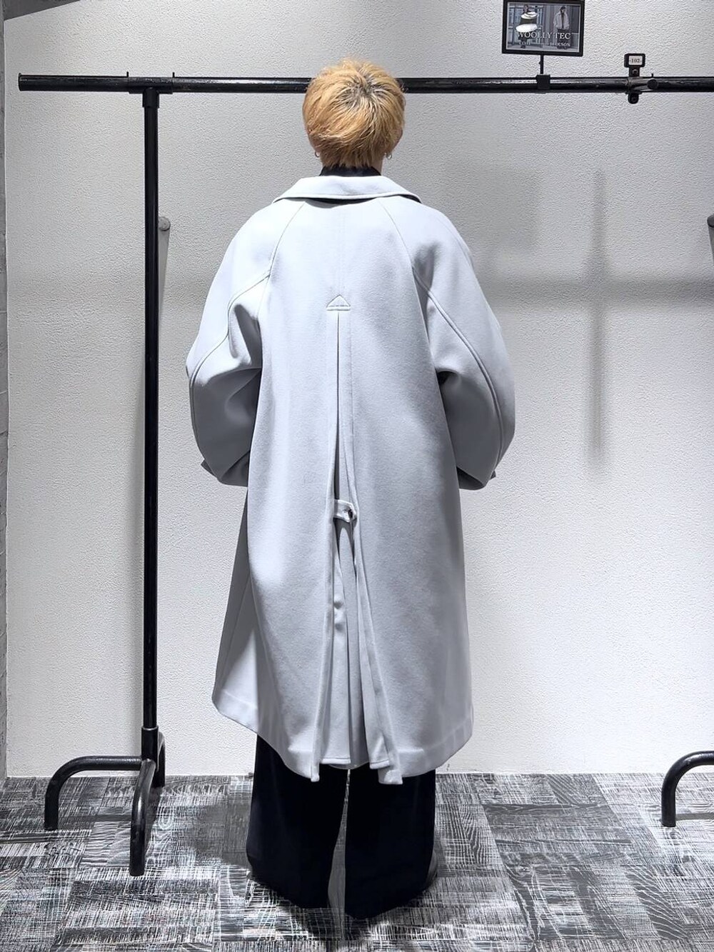 グレー系のステンカラーコート、ブラック系のショルダーバッグ、ブラック系のドレスシューズを着用したメンズの冬コーディネートの4枚目の写真