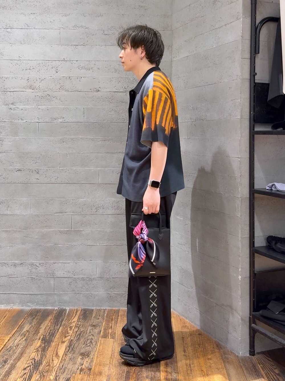 ブラック系のカーゴパンツ、ブラック系のニット/セーター、ブラック系のサンダルを着用したメンズの夏コーディネートの4枚目の写真