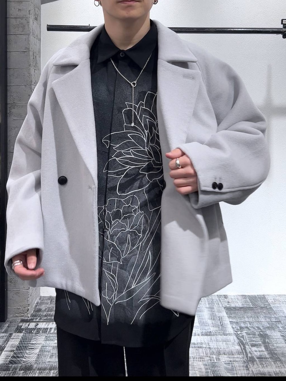 グレー系のブルゾン、ブラック系のスニーカー、ブラック系のスラックスを着用したメンズの冬コーディネートの5枚目の写真