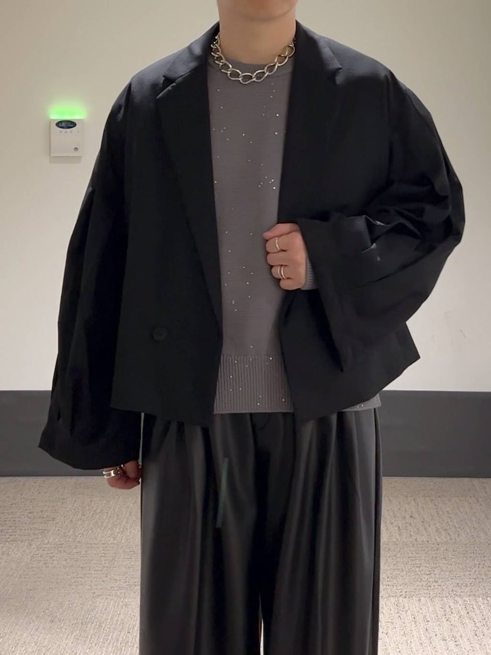 ブラック系のその他パンツ、ブラック系のテーラードジャケット、グレー系のニット/セーターを着用したメンズの秋コーディネートの5枚目の写真