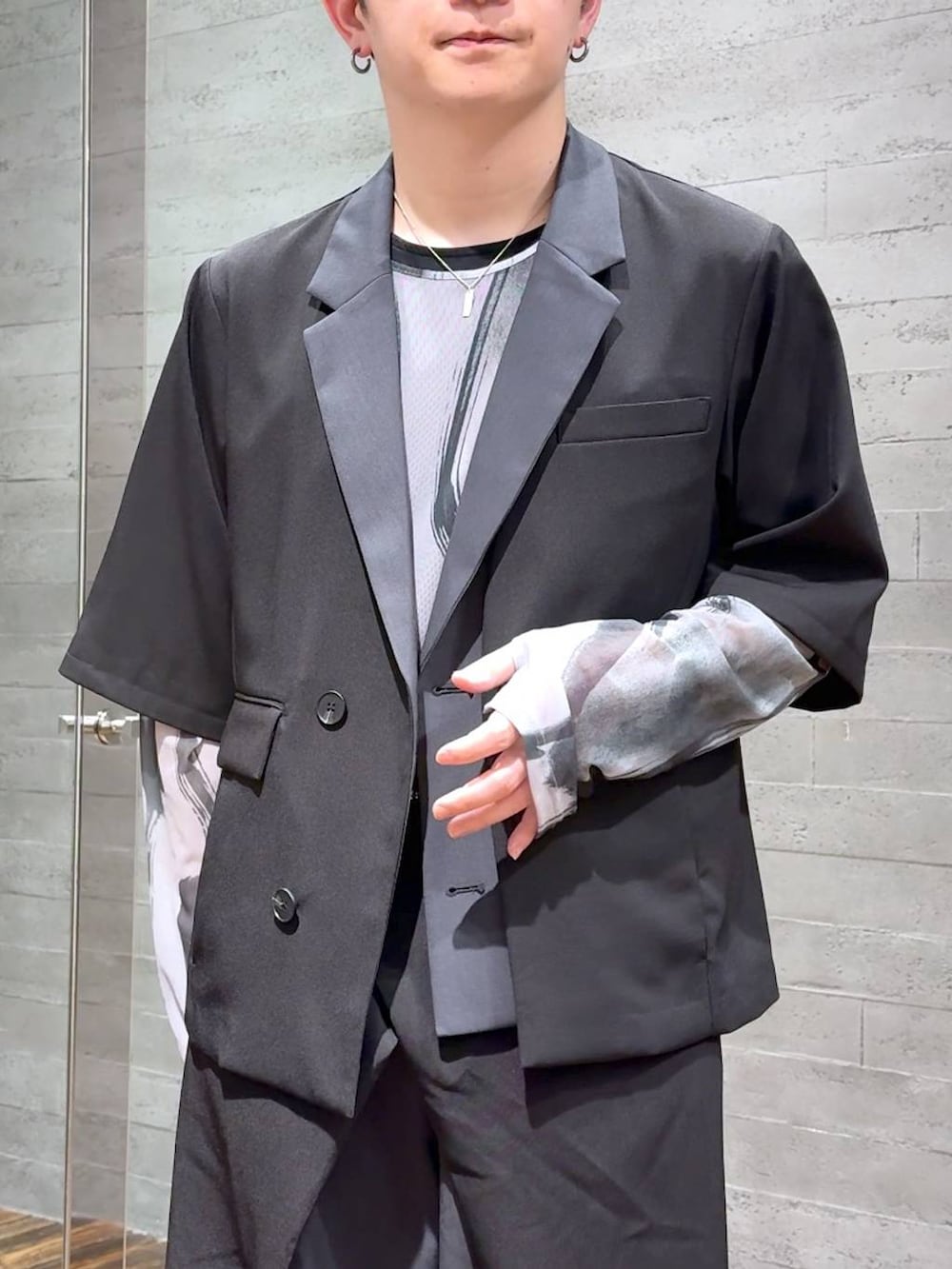 ブラック系のTシャツ/カットソー、ブラック系のサンダル、ブラック系のテーラードジャケットを着用したメンズの春コーディネートの5枚目の写真