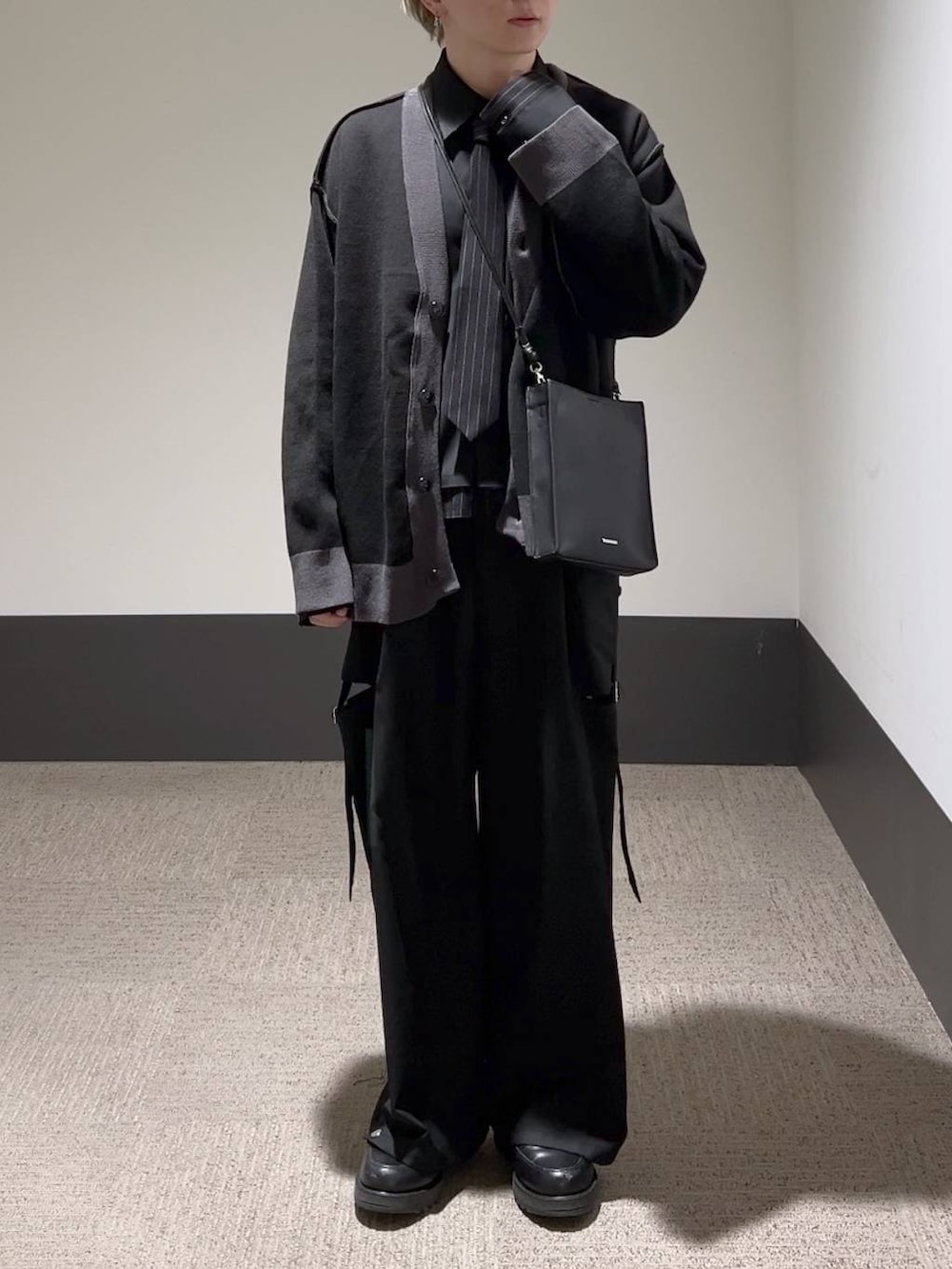 ブラック系のスラックス、ブラック系のカーディガン/ボレロ、ブラック系のシャツ/ブラウスを着用したメンズの冬コーディネートの2枚目の写真