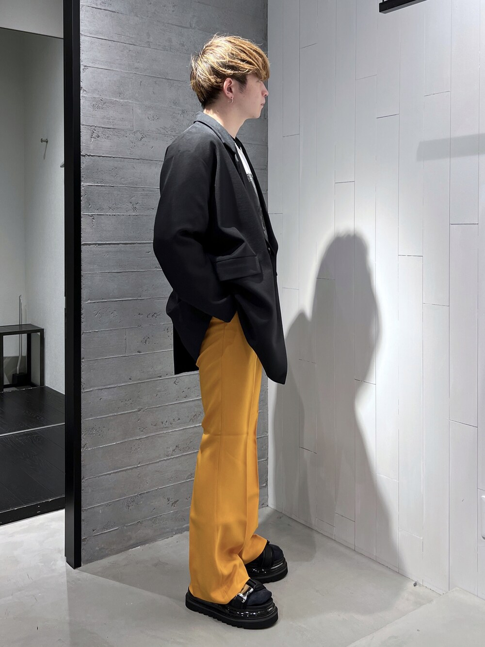 ブラック系のTシャツ/カットソー、ブラック系のテーラードジャケット、イエロー系のスラックスを着用したメンズの春コーディネートの4枚目の写真