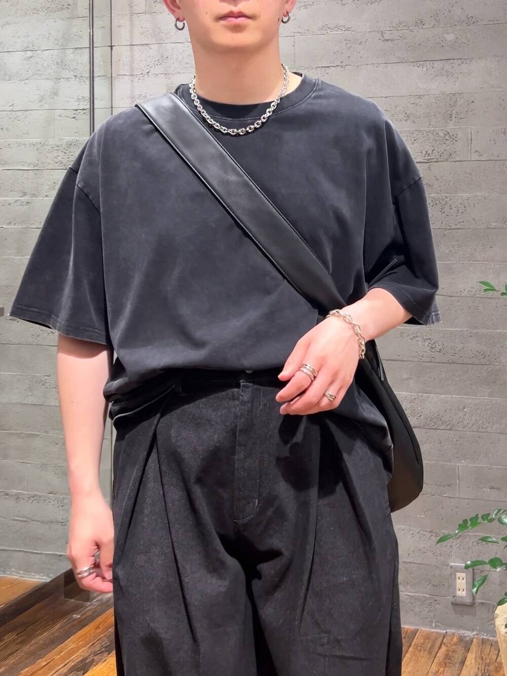 ブラック系のTシャツ/カットソー、ブラック系のスニーカー、ブラック系のデニムパンツを着用したメンズの夏コーディネートの5枚目の写真