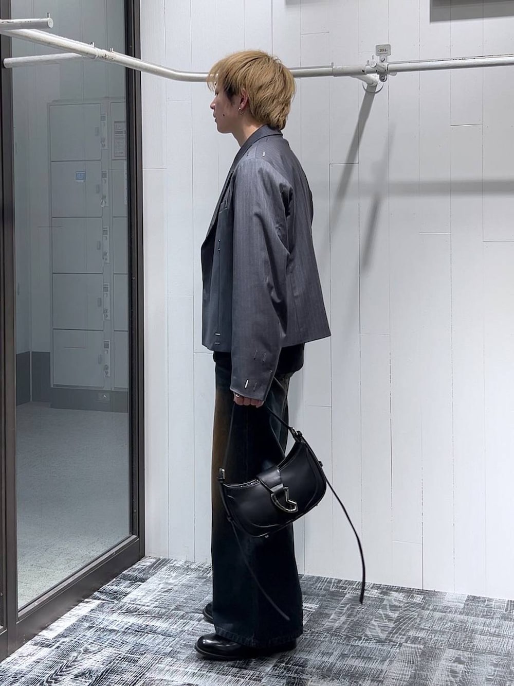 ブルー系のデニムパンツ、ブラック系のTシャツ/カットソー、ブラック系のドレスシューズを着用したメンズの冬コーディネートの4枚目の写真