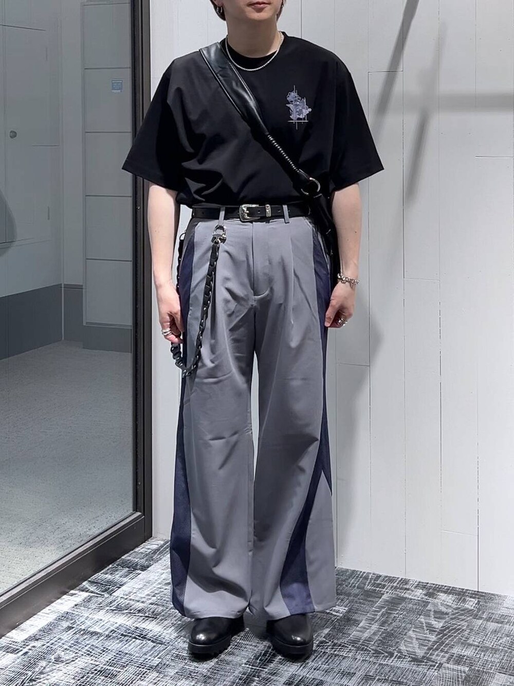 ブラック系のドレスシューズ、ブラック系のTシャツ/カットソー、ブラック系のショルダーバッグを着用したメンズの春コーディネートの2枚目の写真