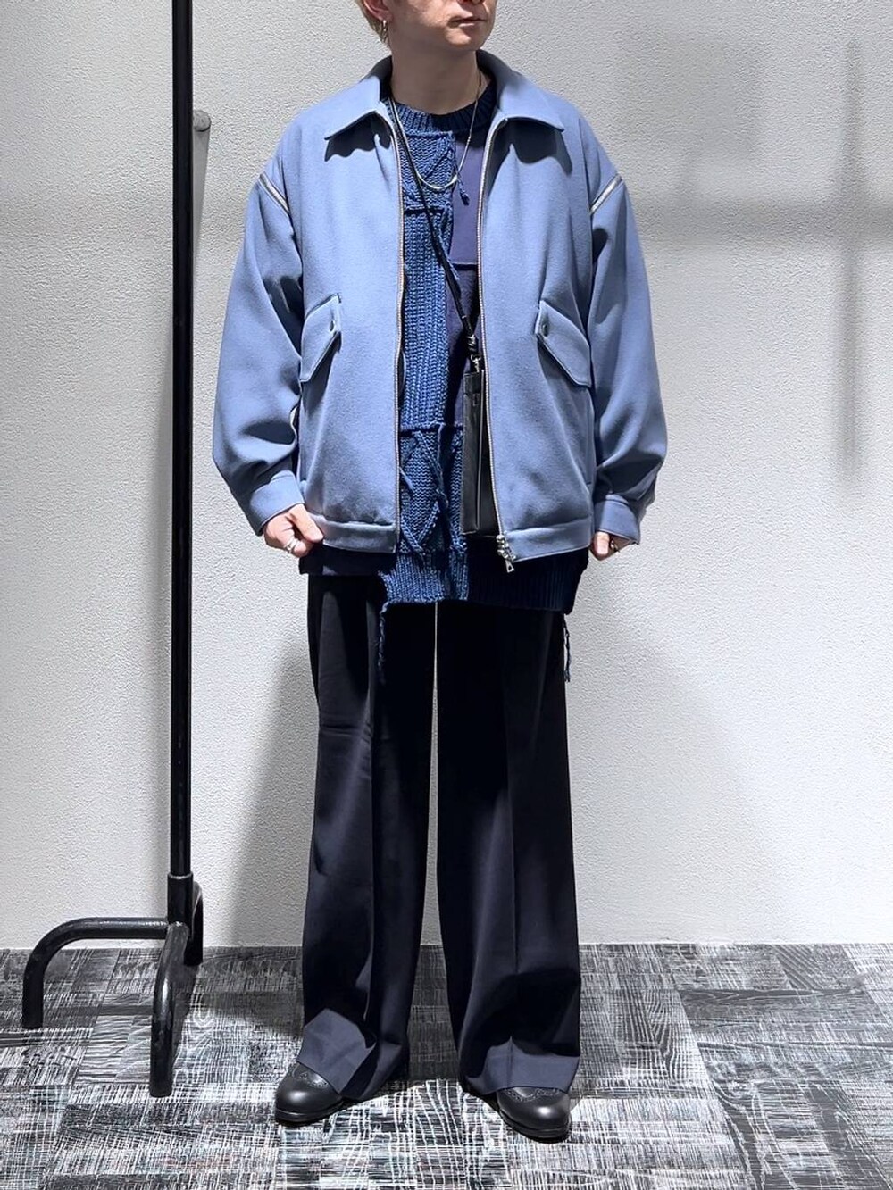 ブラック系のショルダーバッグ、ブラック系のドレスシューズ、ブルー系のブルゾンを着用したメンズの冬コーディネートの2枚目の写真