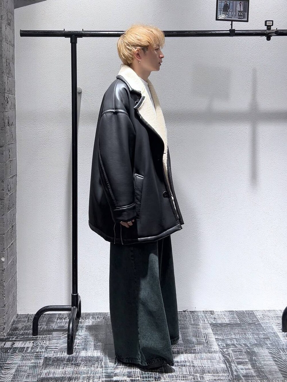 ブラック系のドレスシューズ、グリーン系のデニムパンツ、ブラック系のムートンコートを着用したメンズの冬コーディネートの3枚目の写真