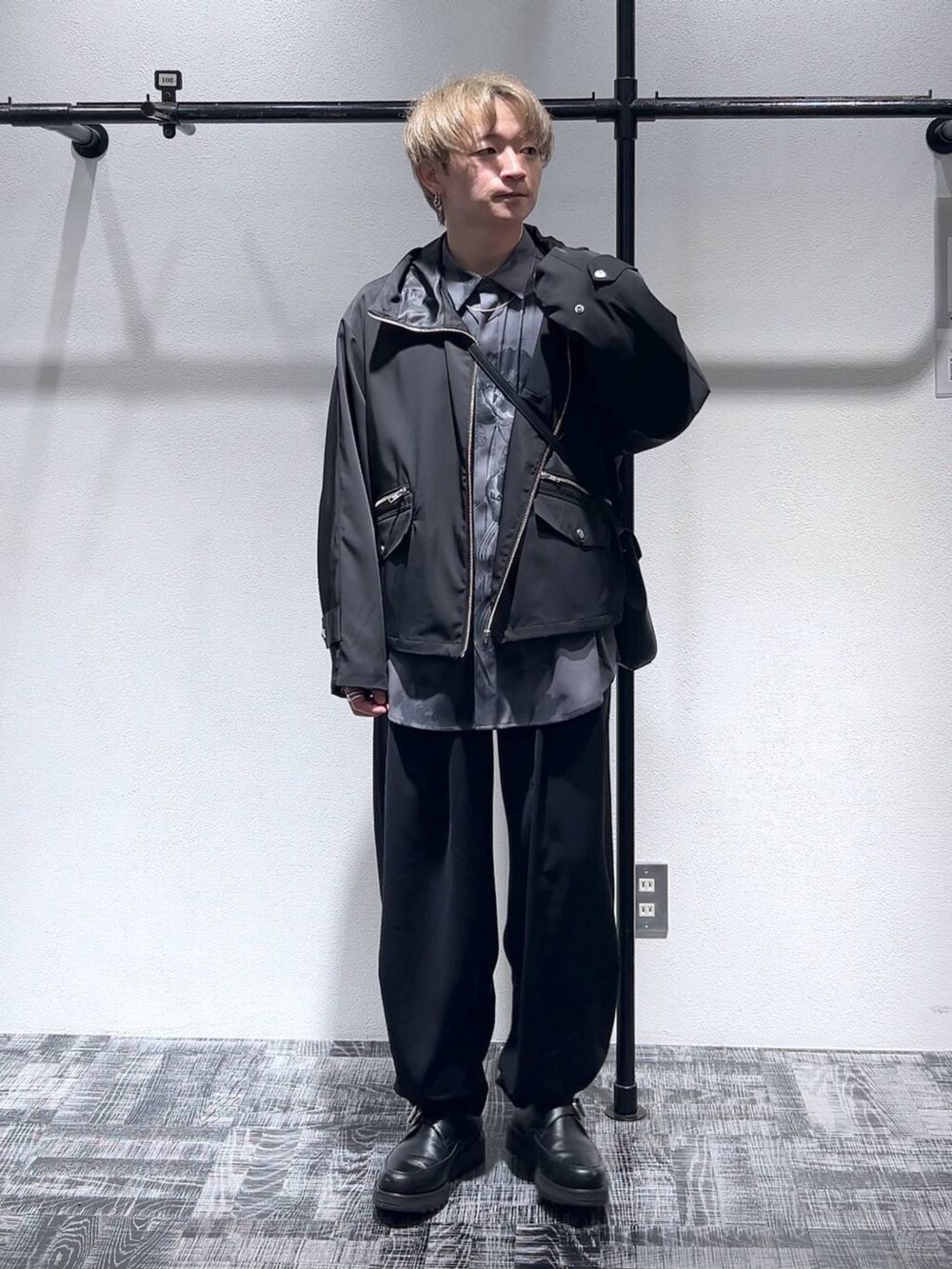 ブラック系のテーラードジャケット、ブラック系のドレスシューズ、ブラック系のショルダーバッグを着用したメンズの春コーディネートの2枚目の写真