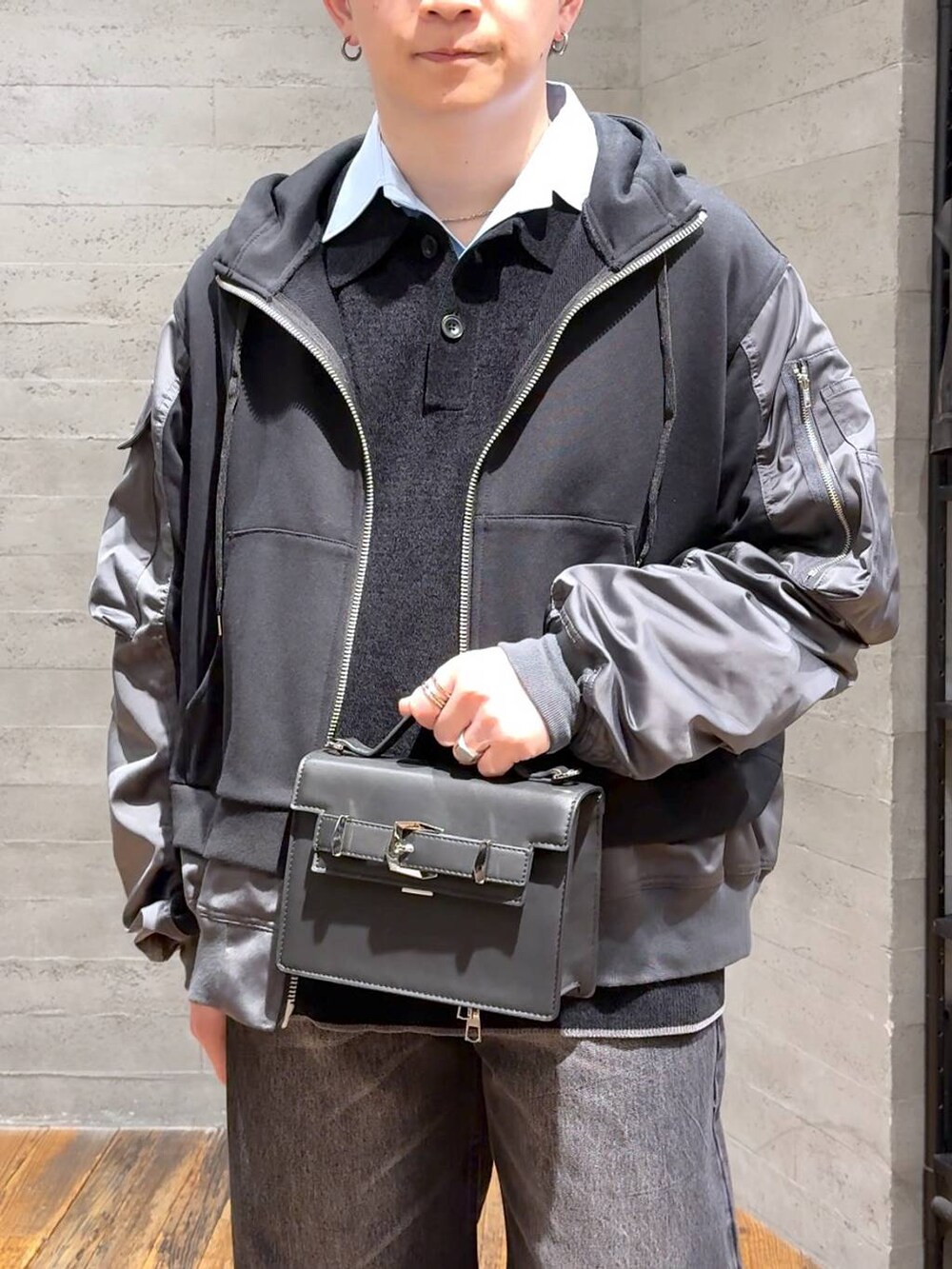 ブラック系のデニムパンツ、ブラック系のポロシャツ、ブラック系のローファーを着用したメンズの冬コーディネートの5枚目の写真