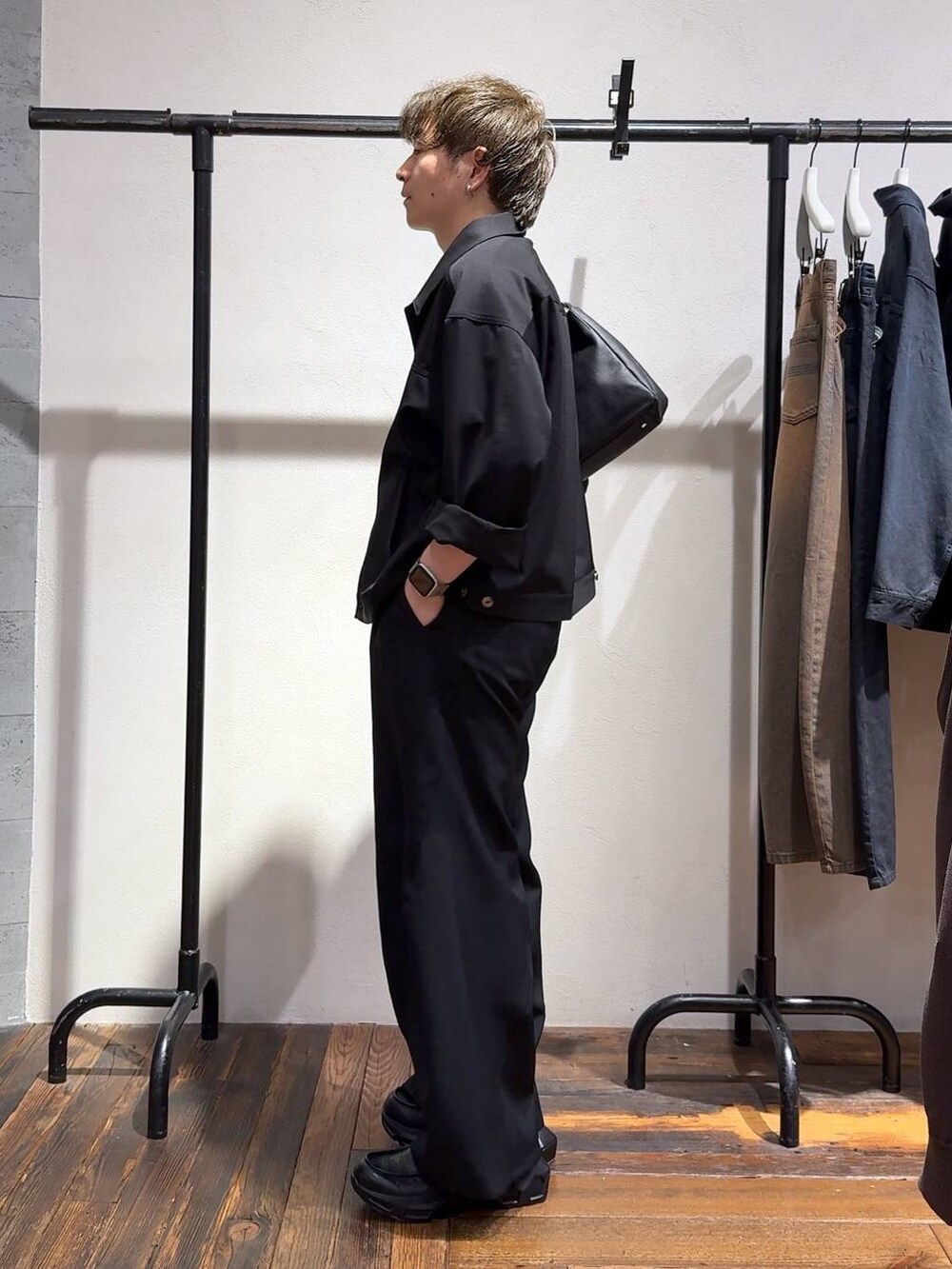 ブラック系のスラックス、ブラック系のローファー、ブラック系のTシャツ/カットソーを着用したメンズの夏コーディネートの4枚目の写真