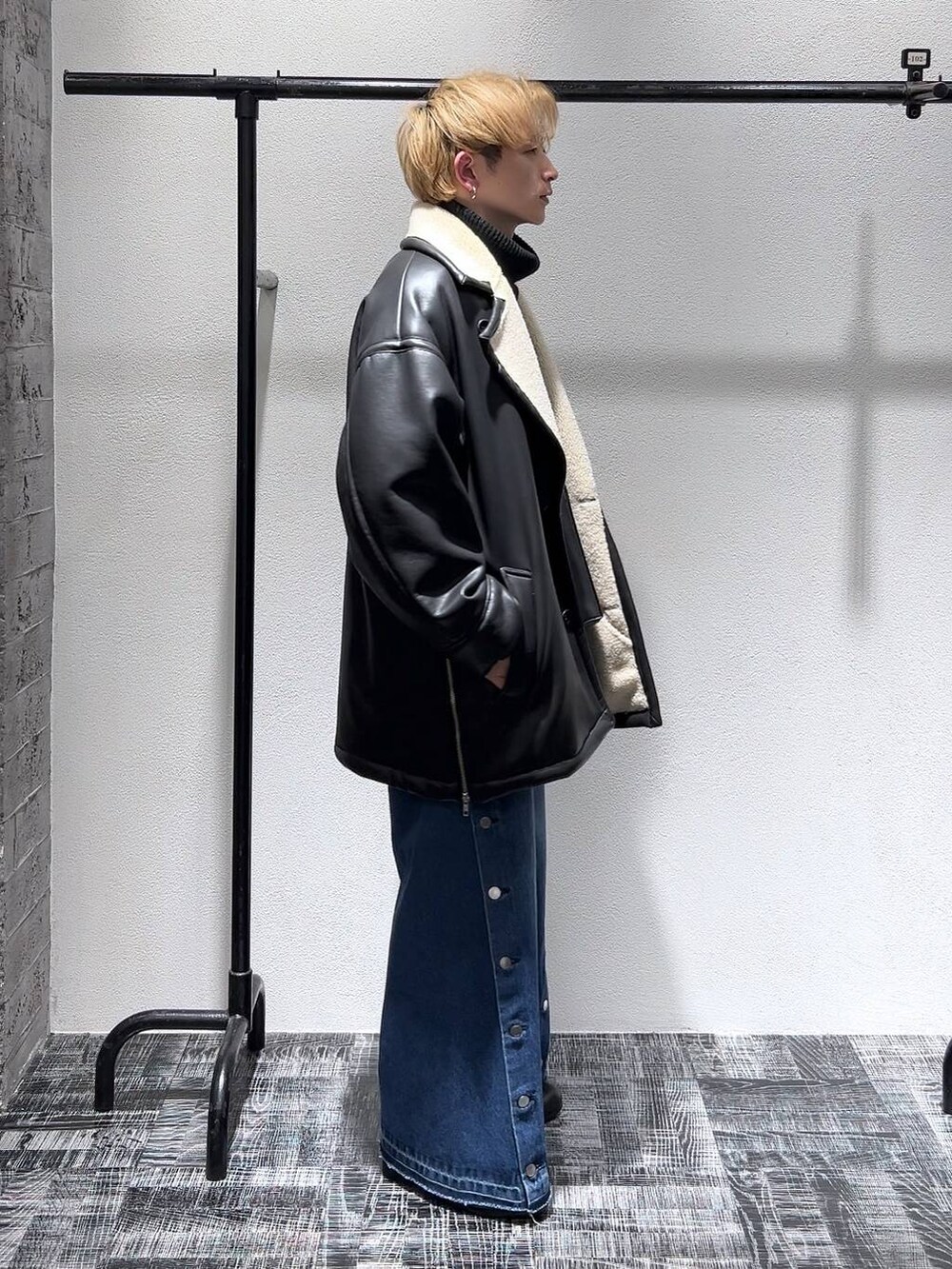 ブラック系のニット/セーター、ブラック系のショルダーバッグ、ブラック系のドレスシューズを着用したメンズの冬コーディネートの3枚目の写真