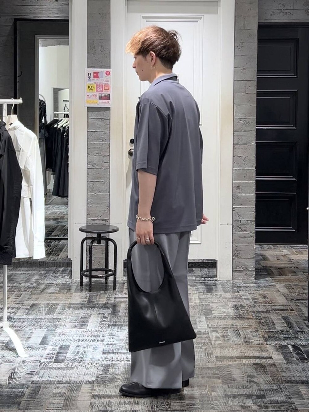 グレー系のスラックス、グレー系のTシャツ/カットソー、ブラック系のTシャツ/カットソーを着用したメンズの夏コーディネートの2枚目の写真
