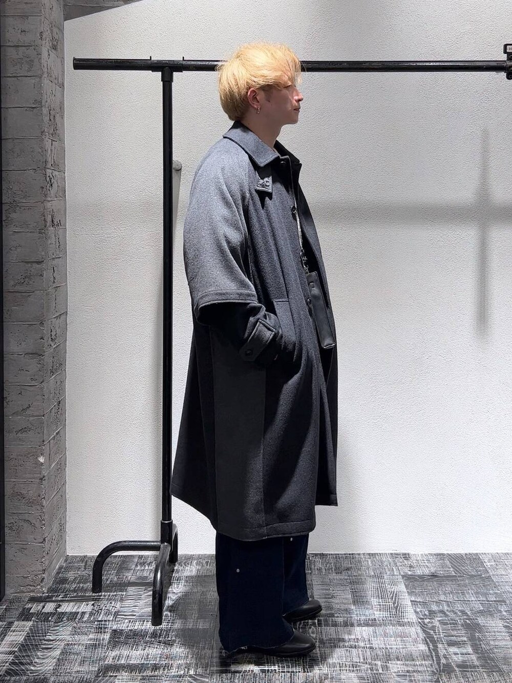 ブラック系のドレスシューズ、ブルー系のデニムパンツ、グレー系のトレンチコートを着用したメンズの秋コーディネートの3枚目の写真