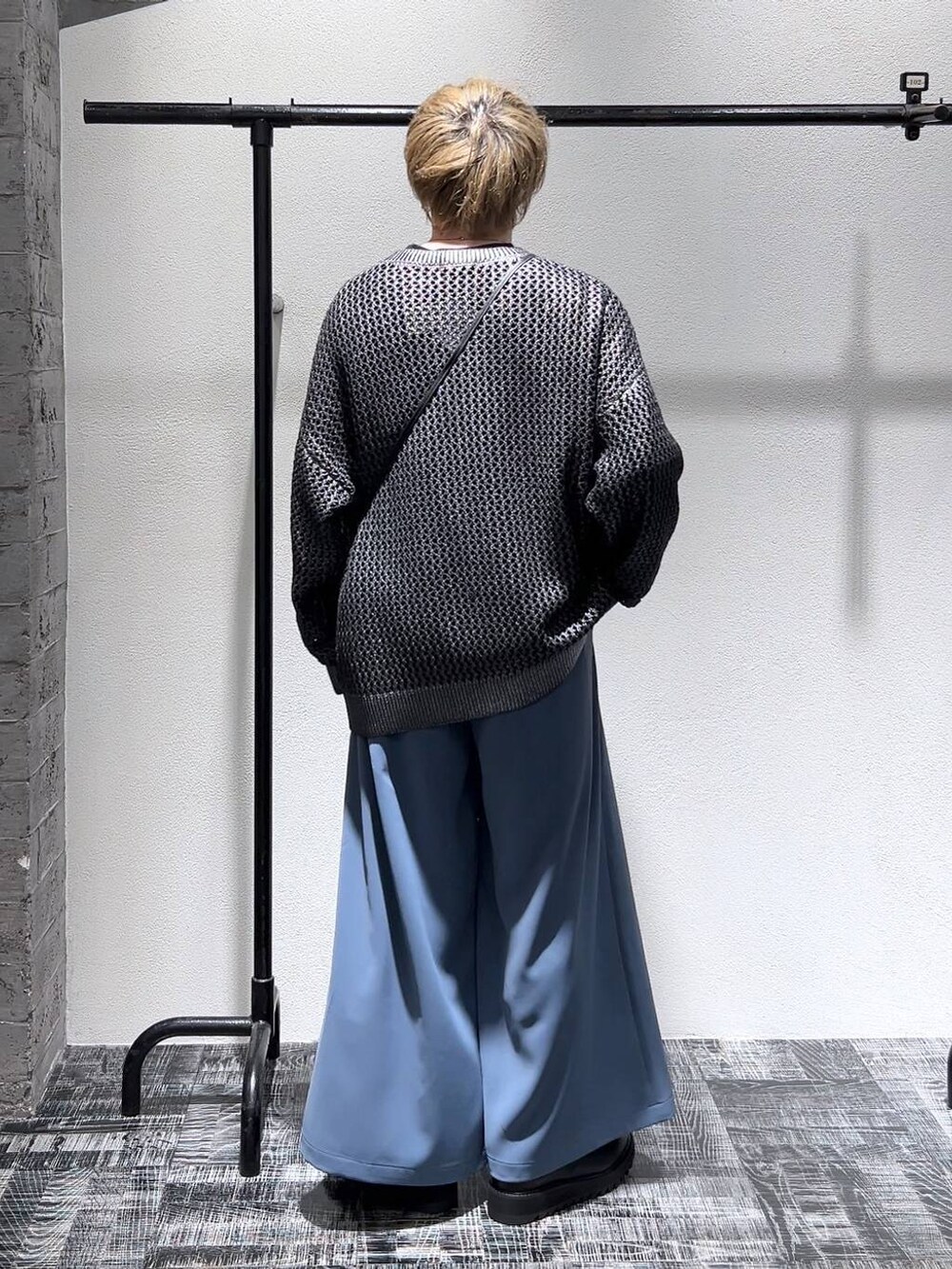 ブラック系のTシャツ/カットソー、グレー系のニット/セーター、ブラック系のショルダーバッグを着用したメンズの春コーディネートの3枚目の写真