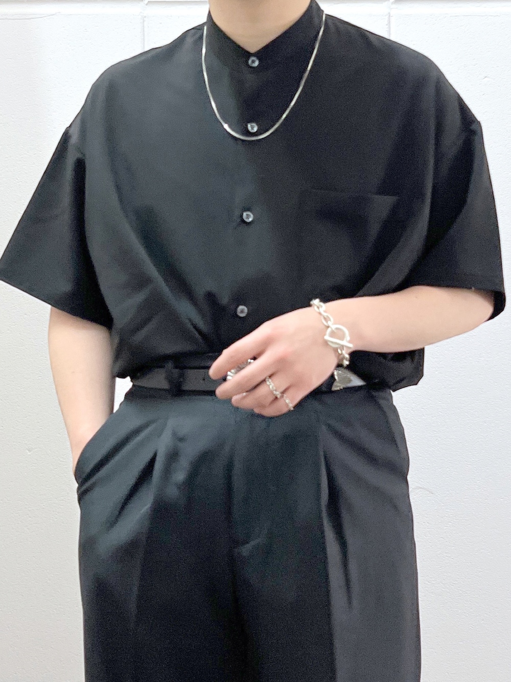 ブラック系のシャツ/ブラウス、ブラック系のスラックス、ブラック系のサンダルを着用したメンズの春コーディネートの3枚目の写真