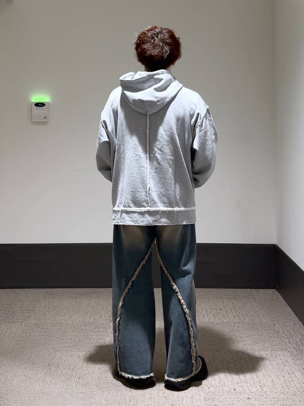 ブラック系のスニーカー、ブルー系のデニムパンツ、グレー系のパーカーを着用したメンズの秋コーディネートの3枚目の写真