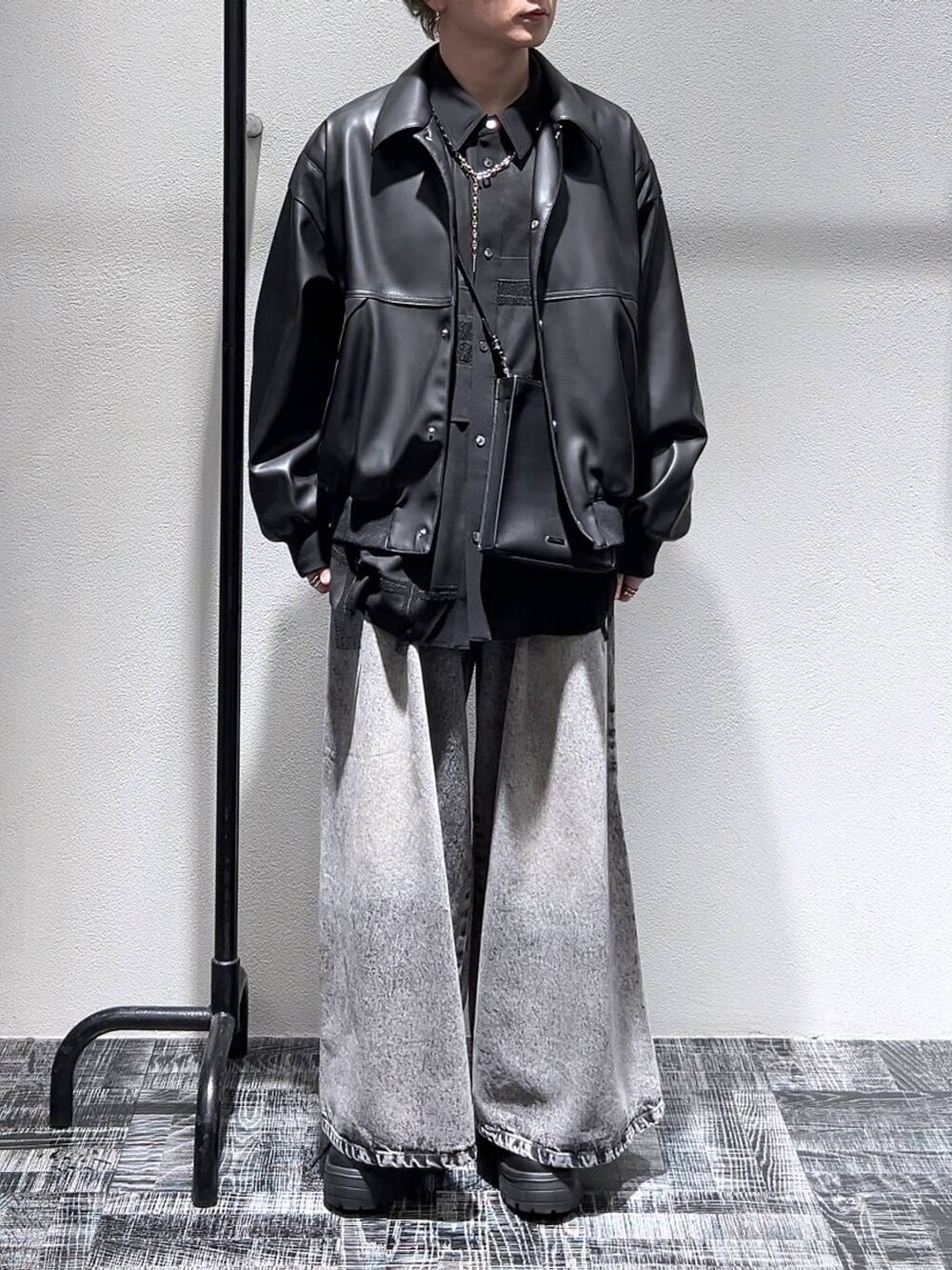 ブラック系のスニーカー、ブラック系のブルゾン、ブラック系のショルダーバッグを着用したメンズの冬コーディネートの2枚目の写真