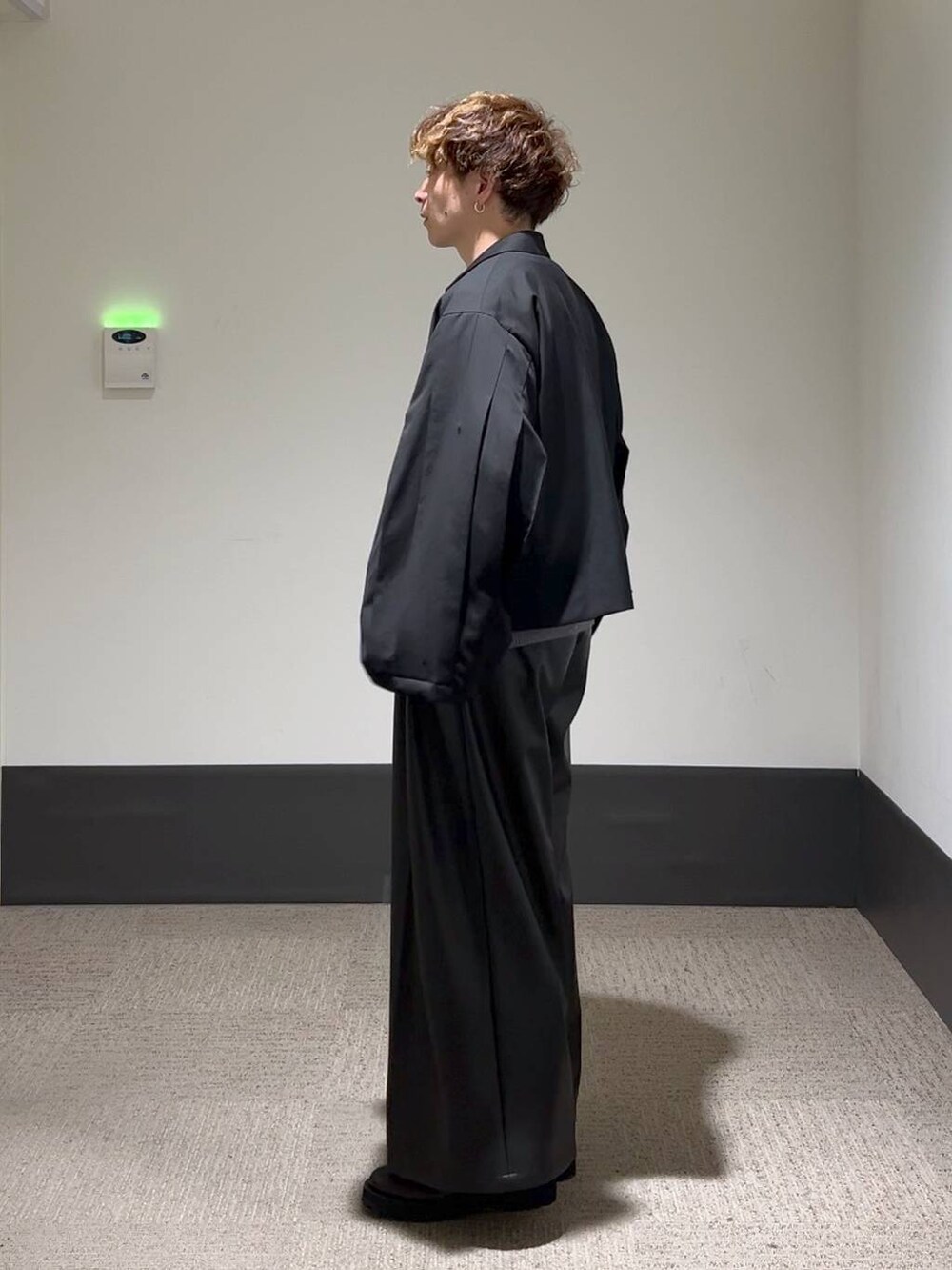 ブラック系のその他パンツ、ブラック系のテーラードジャケット、グレー系のニット/セーターを着用したメンズの秋コーディネートの2枚目の写真