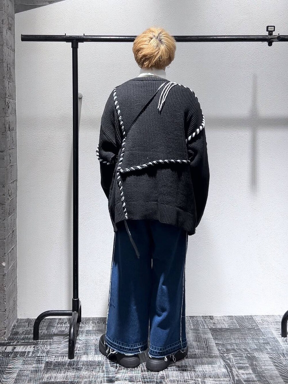 ブルー系のデニムパンツ、ブラック系のショルダーバッグ、ホワイト系のスウェットを着用したメンズの冬コーディネートの4枚目の写真