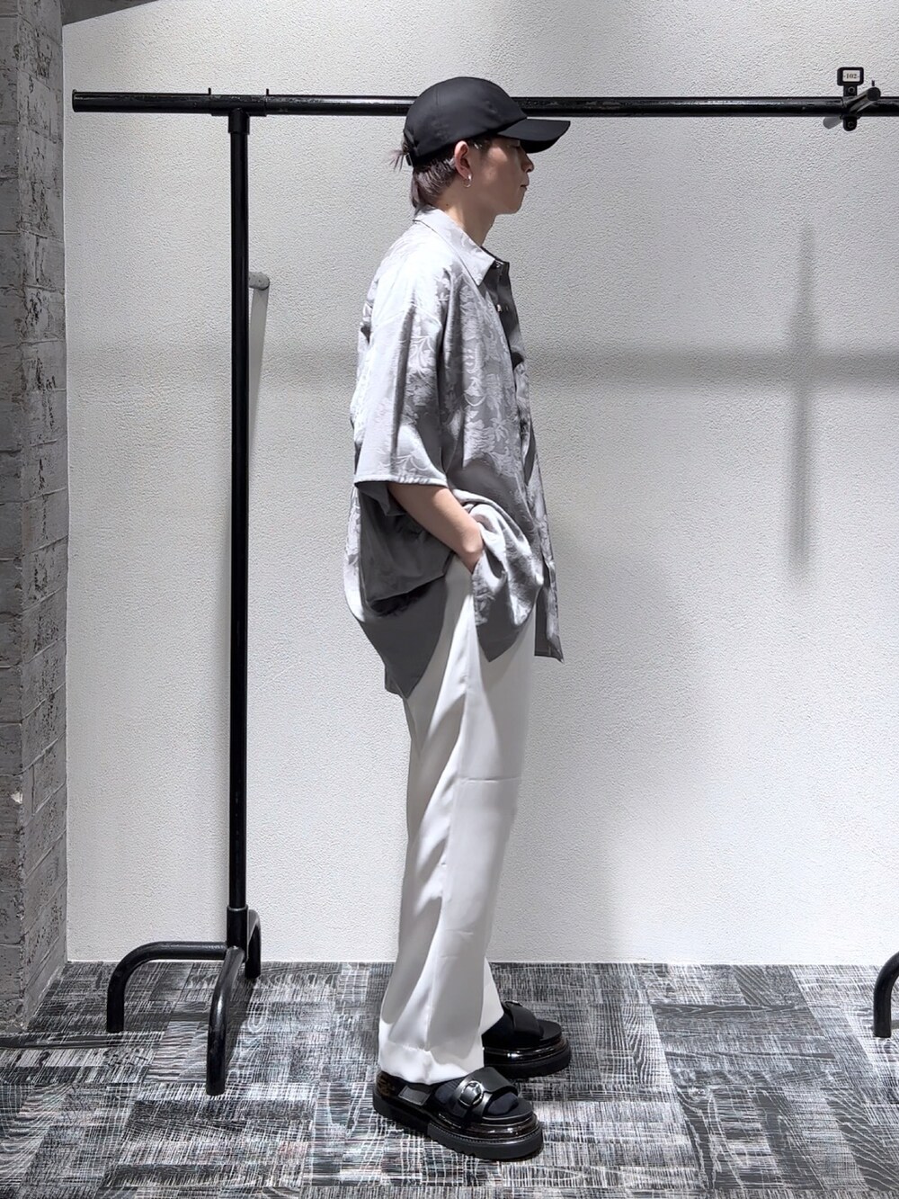 グレー系のシャツ/ブラウス、ホワイト系のその他パンツ、ブラック系のサンダルを着用したメンズの夏コーディネートの3枚目の写真