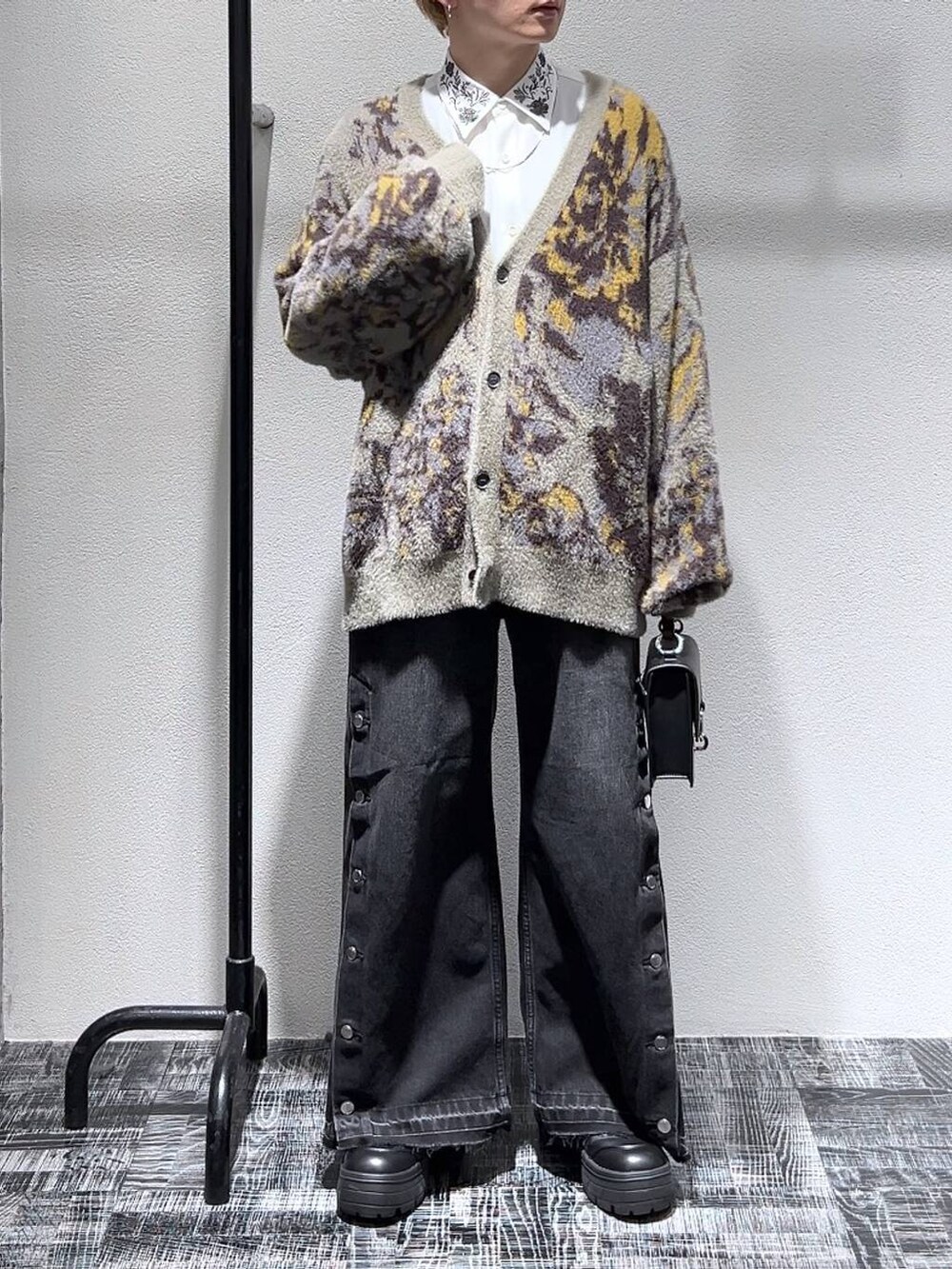 ブラック系のショルダーバッグ、グレー系のカーディガン/ボレロ、ブラック系のブーツを着用したメンズの冬コーディネートの2枚目の写真