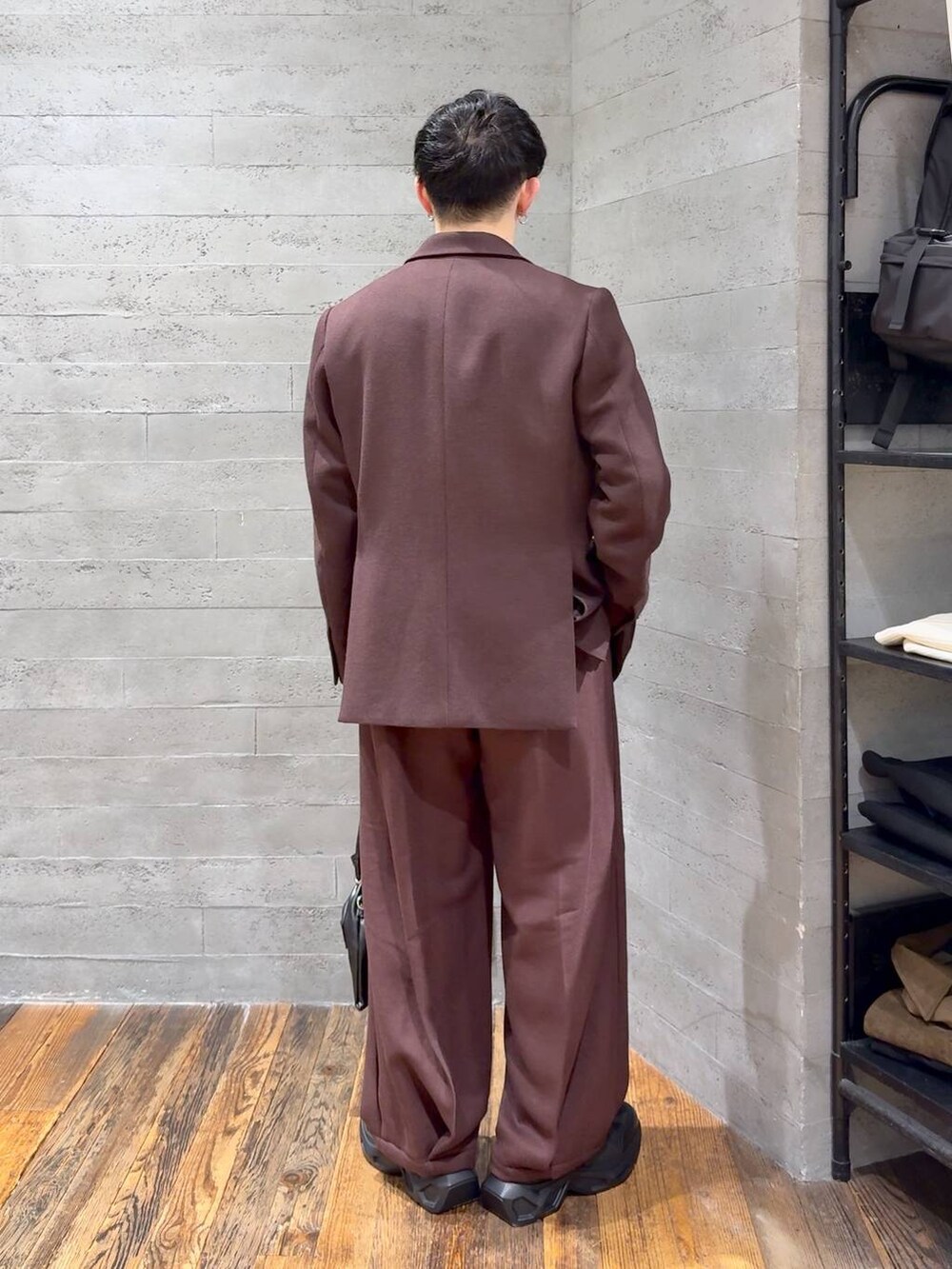 ブラック系のスニーカー、ブラック系のショルダーバッグ、レッド系のスラックスを着用したメンズの秋コーディネートの3枚目の写真