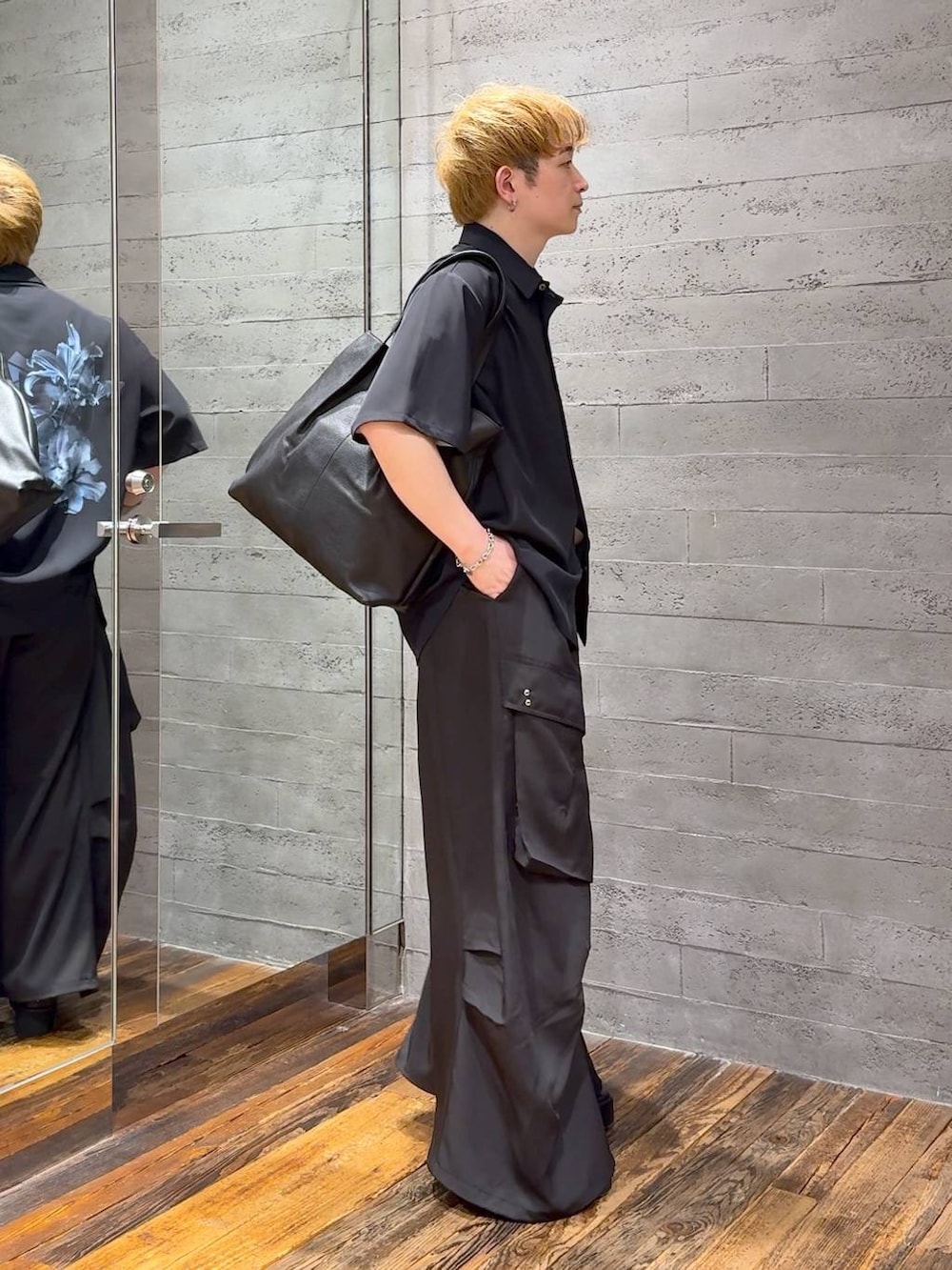 ブラック系のカーゴパンツ、ブラック系のトートバッグ、ブラック系のサンダルを着用したメンズの春コーディネートの2枚目の写真