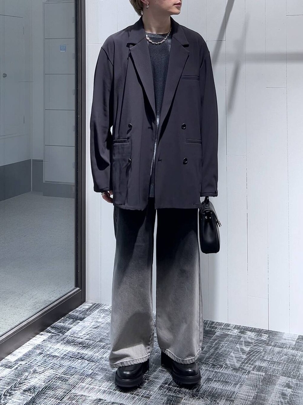 ブラック系のドレスシューズ、ブラック系のショルダーバッグ、ブラック系のテーラードジャケットを着用したメンズの春コーディネートの2枚目の写真