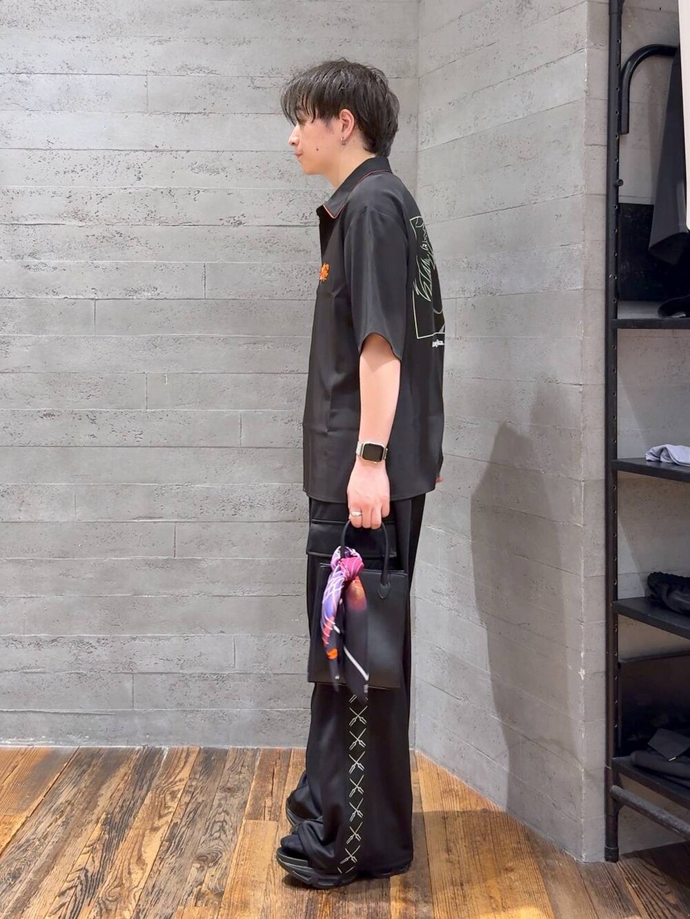 ブラック系のカーゴパンツ、レッド系のシャツ/ブラウス、ブラック系のサンダルを着用したメンズの夏コーディネートの4枚目の写真