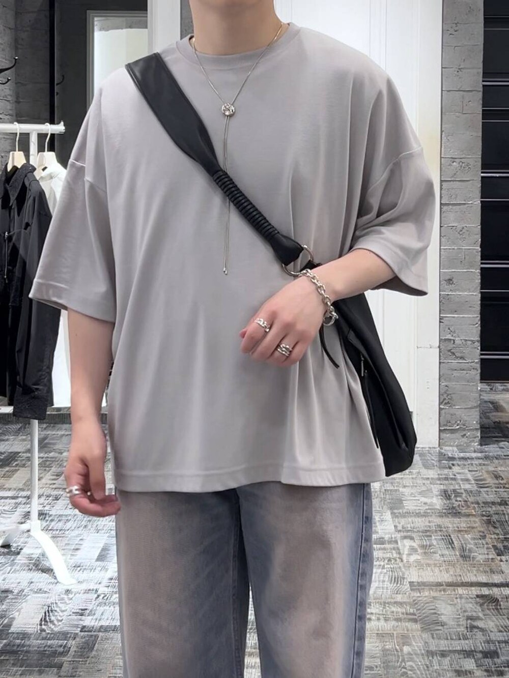 グレー系のTシャツ/カットソー、パープル系のデニムパンツ、ブラック系のサンダルを着用したメンズの夏コーディネートの5枚目の写真
