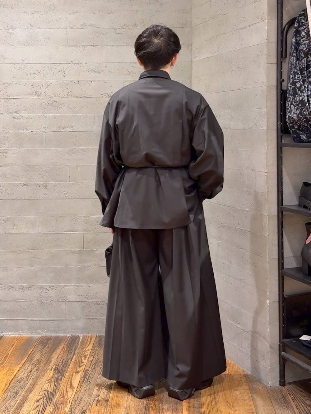 ブラック系のスニーカー、ブラック系のスラックス、ブラック系のショルダーバッグを着用したメンズの冬コーディネートの3枚目の写真