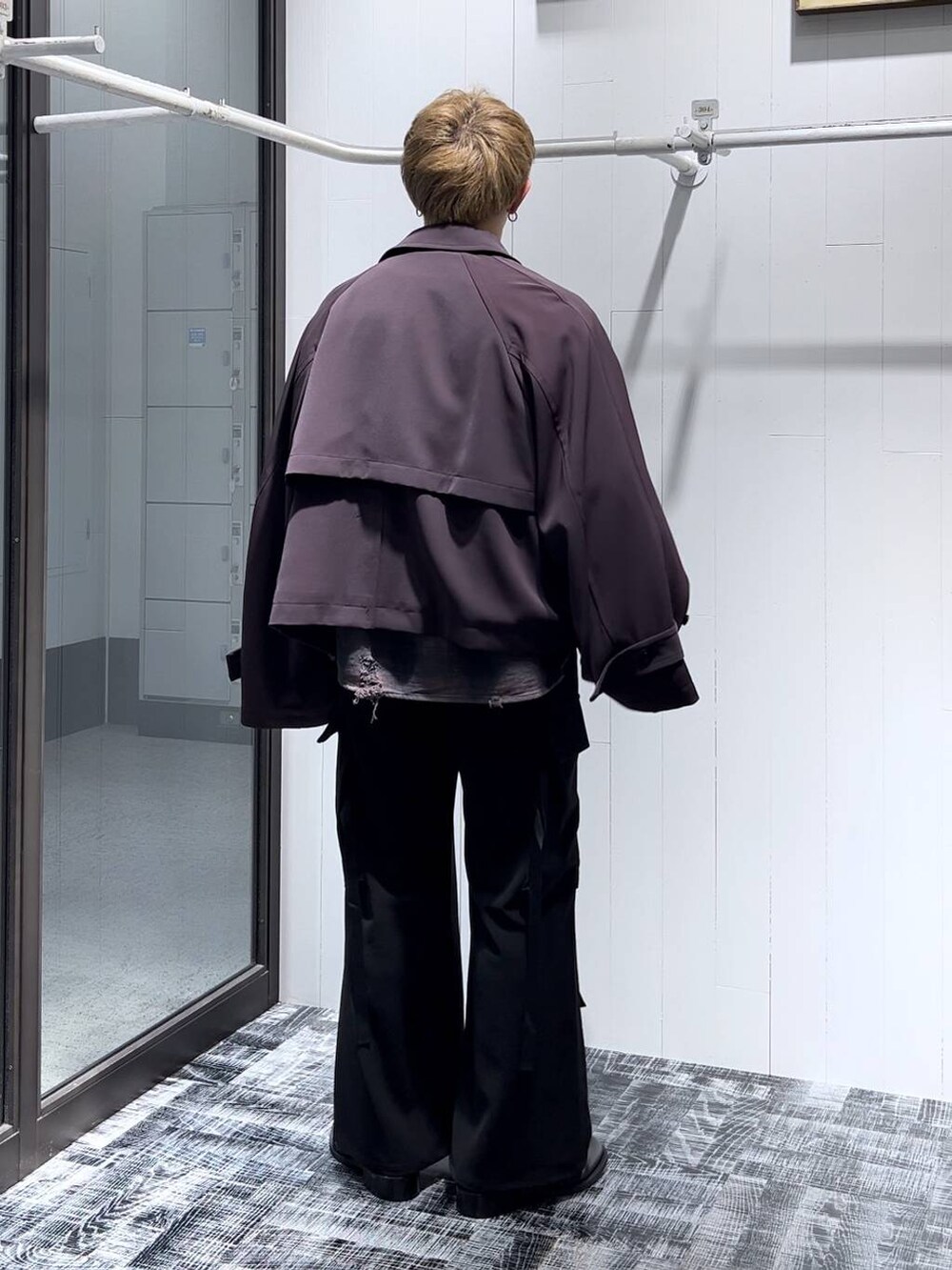 レッド系のブルゾン、ブラック系のカーゴパンツ、ブラック系のドレスシューズを着用したメンズの秋コーディネートの3枚目の写真