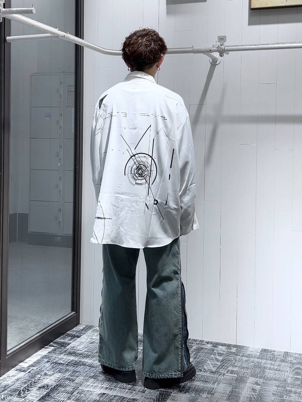 ブルー系のデニムパンツ、ブラック系のドレスシューズ、ホワイト系のシャツ/ブラウスを着用したメンズの夏コーディネートの2枚目の写真