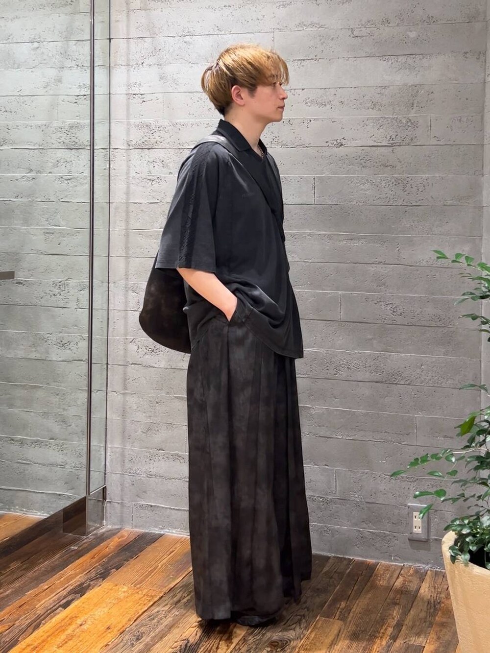 グレー系のその他パンツ、グレー系のショルダーバッグ、ブラック系のローファーを着用したメンズの夏コーディネートの2枚目の写真