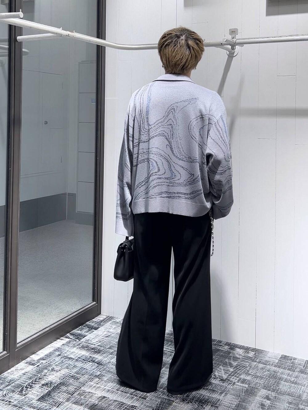 ブラック系のスラックス、グレー系のカーディガン/ボレロ、ブラック系のドレスシューズを着用したメンズの春コーディネートの4枚目の写真