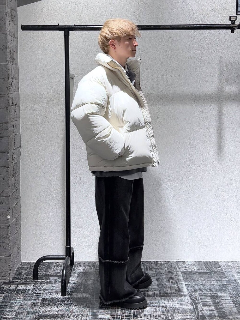 ホワイト系のダウンジャケット/コート、ブラック系のデニムパンツ、ブラック系のネクタイを着用したメンズの秋コーディネートの3枚目の写真